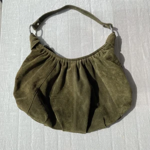Grön mocka väska - Rymlig grön mocka väska. Den är 45 cm på bredden, 24 cm på höjden och axelremmen är 48cm💚💚
