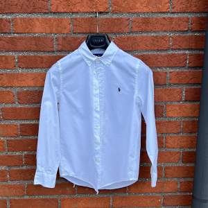 Snygg och stilren vit skjorta från Ralph Lauren. Mycket sparsamt använd och perfekt skjorta till alla tillfällen! (Skjortan är kritvit, alltså inte blå som den ser ut på bilden)