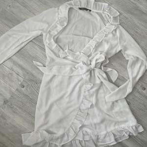 Säljer vit klänning i xs från märket Amelie&me . Vit med volang som bild 2
