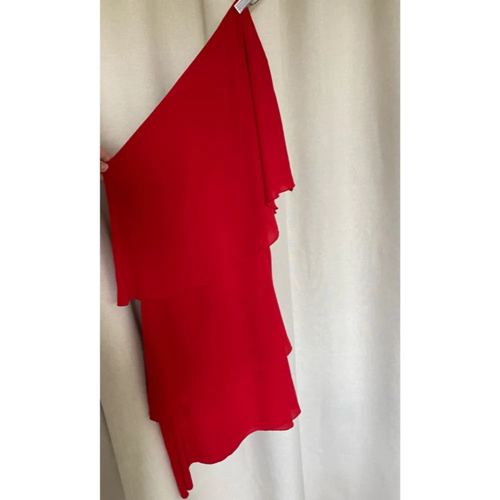 Enaxlad röd kort klänning med volanger från Nelly. Perfekt nu till sommaren ❤️Aldrig använd, nyskick!. Klänningar.