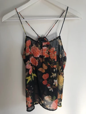 Linne  - Supergulligt lite i genomskinligt material med blommor och fjärilar. Justerbara band i ryggen 