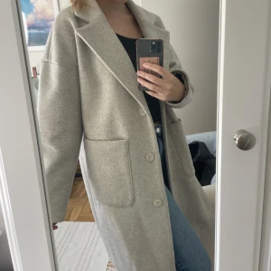 Kappa - Ljusgrå kappa från NAKD i fint skick, går ner till knäna ungefär💙Perfekta höstjackan! 