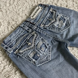 Rock Revival jeans - Rock Revival jeans. ❤️ Lågmidjad och straight/smått bootcut modell, extremt snygga detaljer bak och fram. 🫶 Innerben: 77cm, midja rakt över: 36cm. Är 165cm, kan fixa fler mått. 🥰 Håll koll på min profil, lägger för det mesta upp vintage jeans! 😍