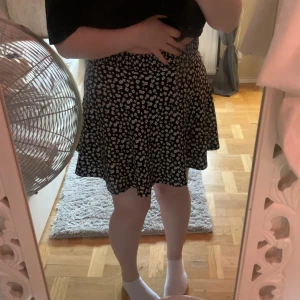 kjol - en lite kortare kjol, svart med vita blommor 