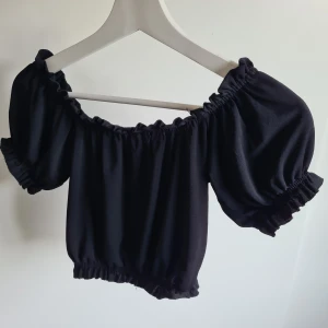 Off-shoulder tröja - En svart off-shoulder topp