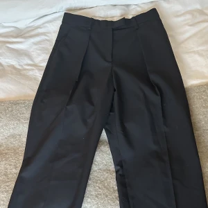 Kostymbyxor Arket - Svarta kostymbyxor i Ull från arket. Strl 42. Byxorna har två fickor framtill samt en fake baktill. De är knappt använda 🖤