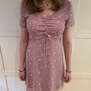 Hollisterklänning - Medellång klänning i nyskick, från Hollister i söt ljuslila/lavendel färg med blomdetaljer. Sitter jättefint på, men säljer pga att färgen inte passar mig. Den är storlek M men passar S också. Priset kan diskuteras