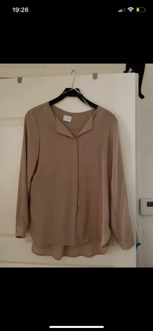 Skjorta - Använd 1 gång, bra skick,mjukt material. Lång, går över rumpan. Längre i bak än i fram. Det går att knäppa upp och ha den öppen.  #vila #skjorta #krage #beige #longsleeve #shirt #buttons 