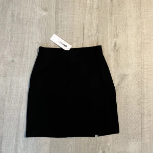 Svart kjol strl XS - Säljer denna fina svarta kjol köpt från Gina tricot. En liten slit ifram. Stl XS. Aldrig använd, lappar kvar. 