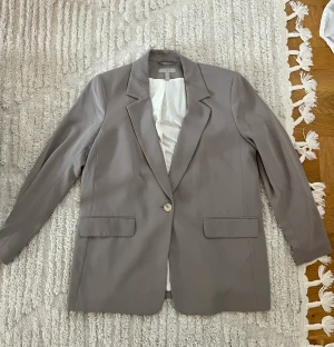 Kavaj HM - Använd cirka 5 gånger, normal i storleken. Kavajen är beige/grå