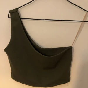 Militär grön one shoulder - Militär grön one shoulder topp köpt på en marknad i Spanien, vet ej storlek men förmodligen en s