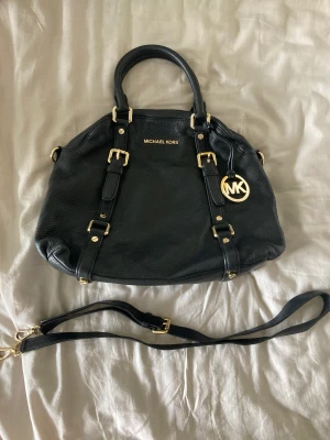Michael Kors väska  - MK Bedford Bowling väska svart. Äkta skinn, använd få tal gånger, väldigt gott skick! Avtagbar rem medföljer. Väskans höjd ca 27cm, bredd: ca 37cm