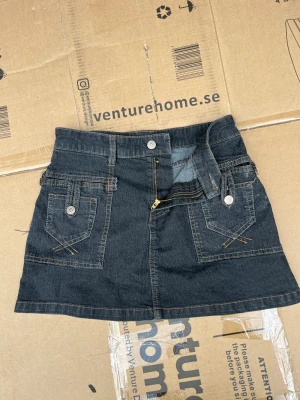 Minikjol - Snygg denimkjol i mjukt material och med snygga detaljer. Köpt second hand i London, men jag har bara använt den en gång. Skriv till mig för bilder på.  