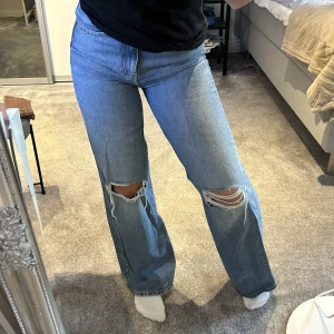 Jeans  - Säljer dessa blåa jeans med slitningar på knäna ifrån lager 157. Säljer pågrund av att de är knappt använda.