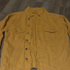 Jeans jacka - Gul jeans jacka med en liten fläck på armen 