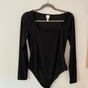 Body - Svart body från H&M i tunnare ribbat material. Fyrkantig ringning. Storlek M Aldrig använd. 