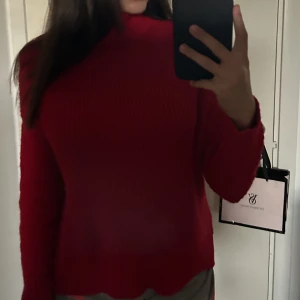 Stickad tröja - En skön röd stickad tröja som inte kommer till användning.