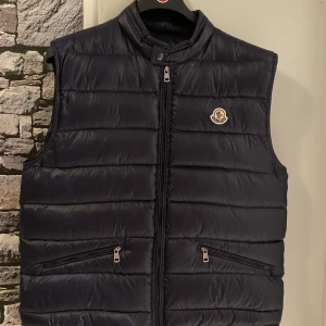 Moncler gui väst - En fin moncler väst i ny skick 10/10. Den är mörkblå men ser svart ut på bilden. Nfc finns!