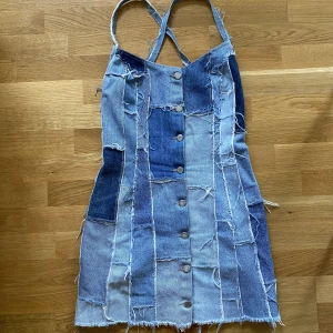 Jeansklänning  - Kort jeansklänning i storlek 36. Supercool! Skickat fler bilder man vill se. Öppen i ryggen. Kort! Jag är 169 och den går precis över rumpan på mig. 