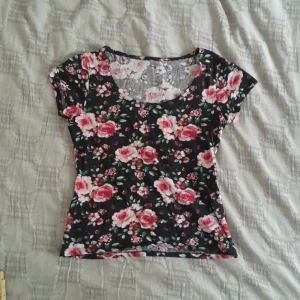 Blommig T-shirt - Varan är cirka 51 cm lång och 37 cm bred. Varan är i ett utmärkt skick. 