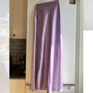 Lila maxikjol  - Ljus lila lång kjol, tajtare upptill och något utsvängd nertill