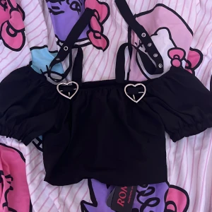 Svart topp med kedjor - Säljer för att den inte kommer till användning, fint skick och har inga fläckar på sig! Använt Max 1 gång vid testning! Har ett stretchigt band vid ryggen (bild 3) Klicka på köp om du vill köpa, kontakta om du har frågor!