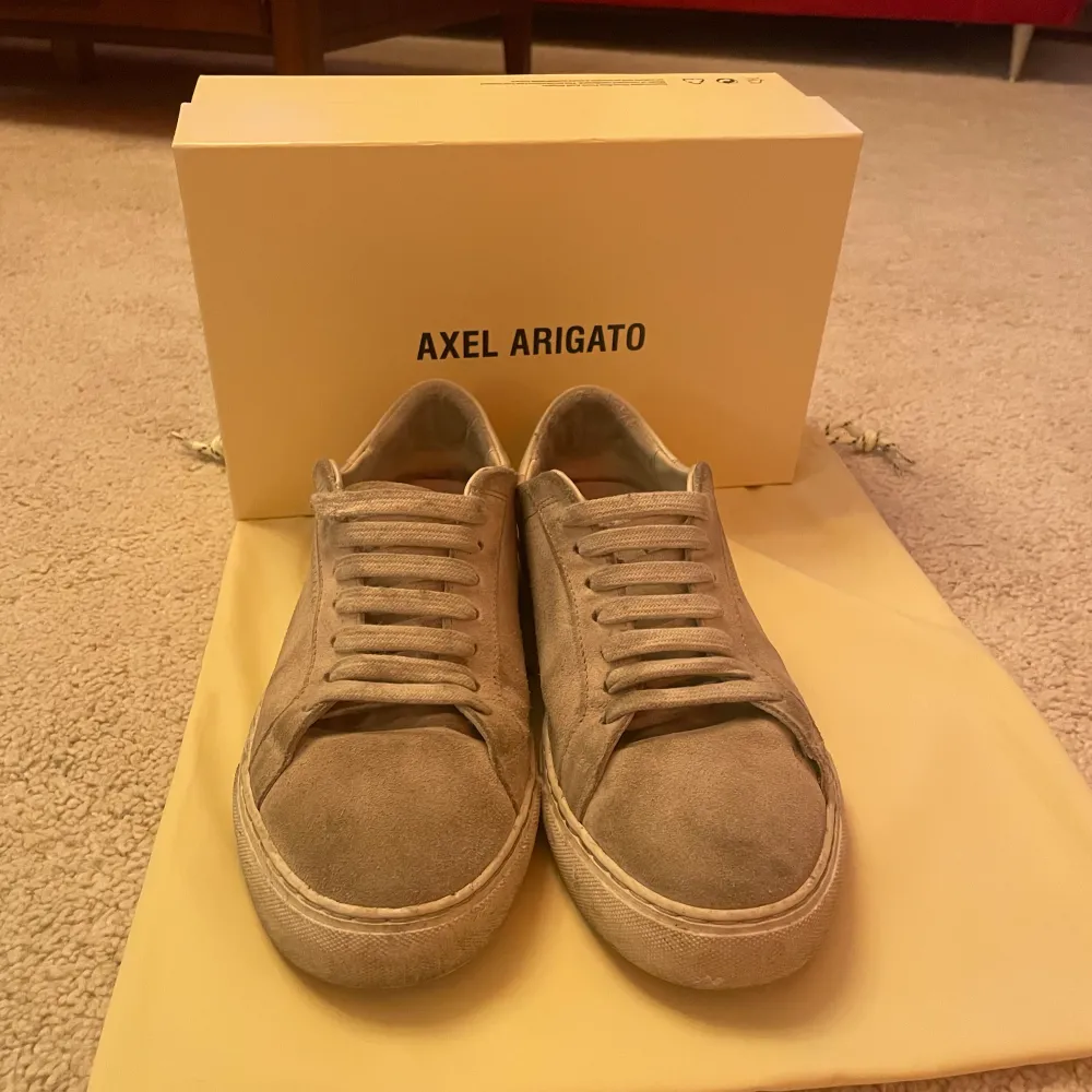 Ett par Axel Arigato sneakers i färgen beige. Skorna är i storlek 40 och är i bra skick.  Box och dustbag fås med. Skor.