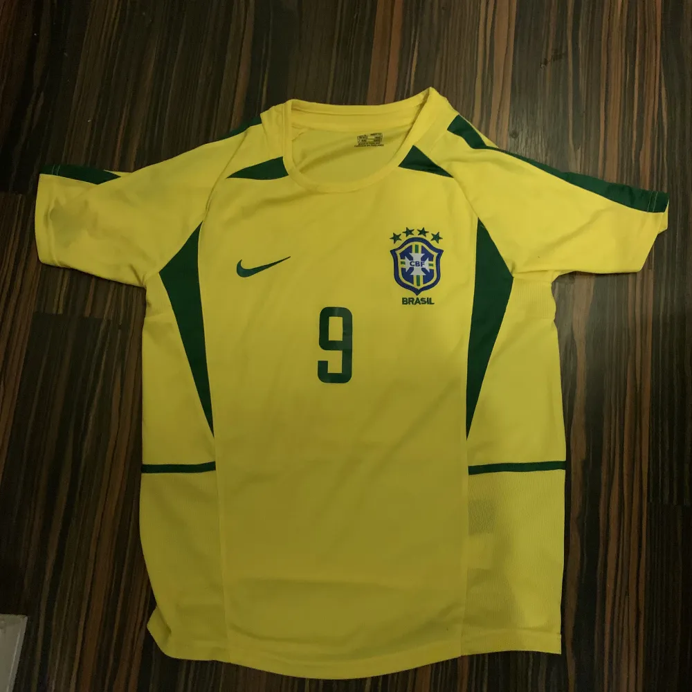 Jag säljer min snygga Ronaldo (R9) retro brasilientröja från deras VM 2002 eftersom den passar inte mig. Perfekt skick då den bara är testad. Skriv för mer info/bilder!. T-shirts.