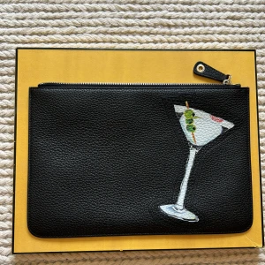 Fendi clutch 👝 - Mycket fin Fendi cloutch i läder. i väskan finns inga fack eller fickor. Inköpt för 9000 kr på Vestarie Colletive.  Mått : 30 x 20 cm.  Använd vid ett bröllop. Inga defekter eller tecken på användning. Nyskick Skriv gärna vid frågor om väskan. 