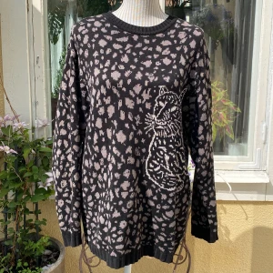 Svart leopard tröja - Cappuccini - En second hand köpt tröja som är väl använd. Den har en liten tråd som sticker ut på framsidan av tröjan och  några få till som inte är lika synliga. Annars i mycket bra skick. 