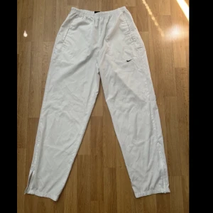 Nike vävda byxor S/M - Vita utsläppta byxorna som skulle sitta bra med ett par nike tn skor och en fotbolls t-shirt. Byxan är i mycket bra skick!