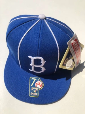 B keps - Fick den av en Kommpis och behöver den inte vet ej vad det är för märke men jag vet att det är ett B på den står att det är amrican needle