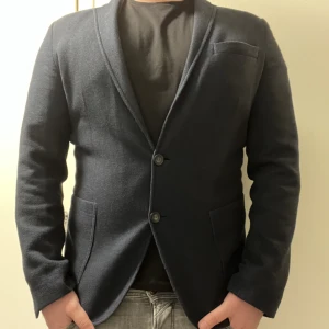 Kavaj - Sjukt skön och stilren kavaj i stickad stil, mörkblå färg och storlek M/L. Riktigt skönt plagg vid utgångar eller bara vardagligt med en tisha under. Släpper den då den knappt används. Väldigt bra skick, 9/10, knappt använd. Mitt pris: 299 SEK