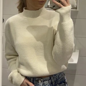 Stickad tröja - En fin creme vit stickad tröja från Pull & Bear. Tröjan är i fint skick utan nopper och är i ett jättemjukt material. Den har en mudd i slutet på tröjan som gör att den sitter fint på. Den är storlek men är som en S.  