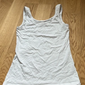 Vitt linne - Ett vitt linne med tjockare band från bondelid. Aldrig använt då den inte rintigt passar mig. Lite skrynklig på bilden men kommer bäde tvätta och stryka innan den skickas. 