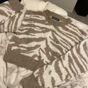 Tröja - Säljer en fin stickad kortare tröja som aldrig kommer till användning. Nyskick, använd Max 2 gånger. Zebra spräckligt mönster.