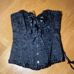 Svart korsett - Svart korsett köpt på second hand. Banden i ryggen är löstagbara, vissa knappar är lite repiga 💓