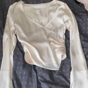 en vit blus med slits i armarna från H&M, som har en dragkedja i ryggen. 