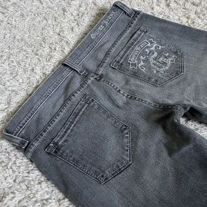 Vintage Guess jeans grå - Bootcut och lågmidjad modell med snygga detaljer där bak. Är lite slitna längst ner. ❤️ Innerben: 85cm, midja rakt över: 41cm. Är 165cm, kan fixa fler mått. 🫶Håll koll på min profil, lägger för det mesta uppp vintage jeans! 😍
