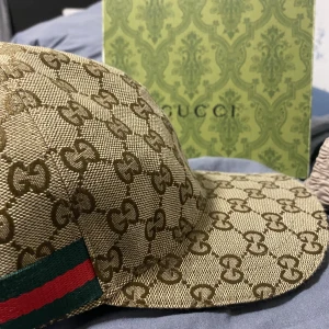Gucci keps - Säljer denna gucci keps som jag fått i present men därmed att jag inte tycker att den är så snygg och passar abslout inte min stil den är ganska ny använd ett fåtal gånger,kepsen ser ut som o vara ny