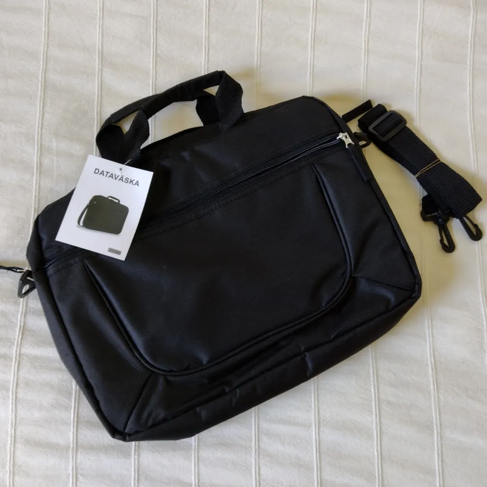 Oanvänd lätt svart dataväska med avtagbar axelrem. . Väskor.