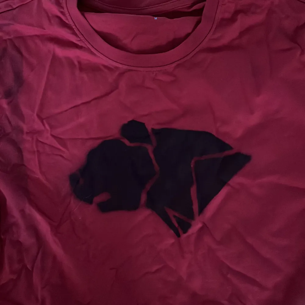 En enkel oanvänd röd t-shirt med ”björnarna” loggan från Wildkids! En superenkel utklädnad till halloween, du behöver bara lägga till lite svarta streck på kinderna 😍   OBS det är lite svart sprayfärg i hörnet på ena ärmen från när jag sprayade den :). T-shirts.