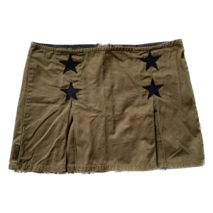 Tripp nyc kjol med stjärnor - Sååå cool militärgrön kjol från tripp nyc med stjärnor!! Inte sätt några defekter. Strlk L. Mått; 41cm i midjan (mätt rakt över) och 34cm i kjollängd. 