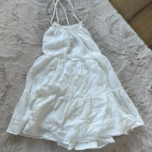 Klänning  - Vit kort klänning som har knytning i ryggen, aldrig använd🩷