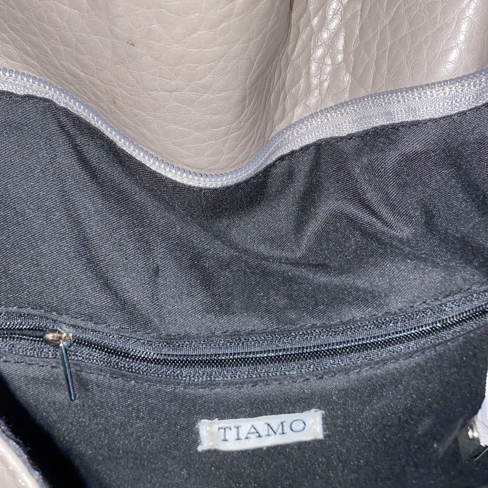 En kedjeväska från Tiamo i använt men fint skick. Den har tre fack inuti varav ett med dragkedja. Väskor.