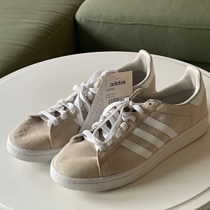 Beiga Adidasskor - Säljer dessa helt oanvända adidasskor i modellen campus. De är helt oanvända med lapparna kvar, men köpta för något år sedan. Därför finns Inte heller färgen kvar längre att köpa.☺️