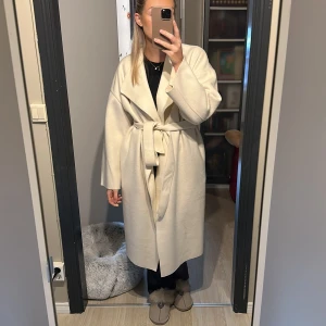 Vit kappa  - Kappa från Nelly från kollektionen med Bianca Ingrosso, använd 1 gång.  Svart sträck på baksidan av högra ärmen som säkert går bort i tvätten