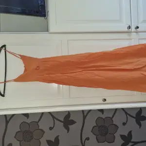 Orange klänning  Hämtas hos mig