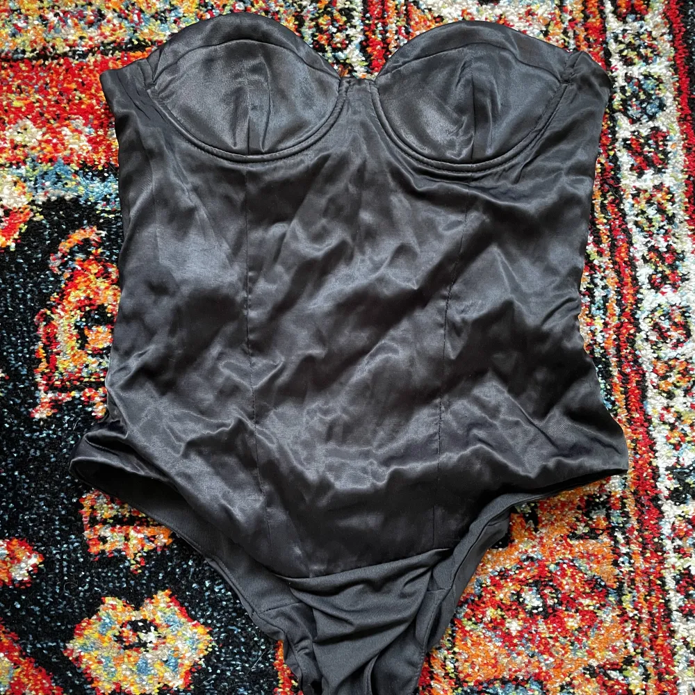 En armlös satin body, funkar perfekt som lite finare topp. Storlek M men liten i storleken 🖤. Toppar.