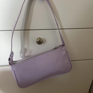 Lila handväska  - Denna lila handväska är endast använd en gång men är supergullig nu till våren och sommaren. 